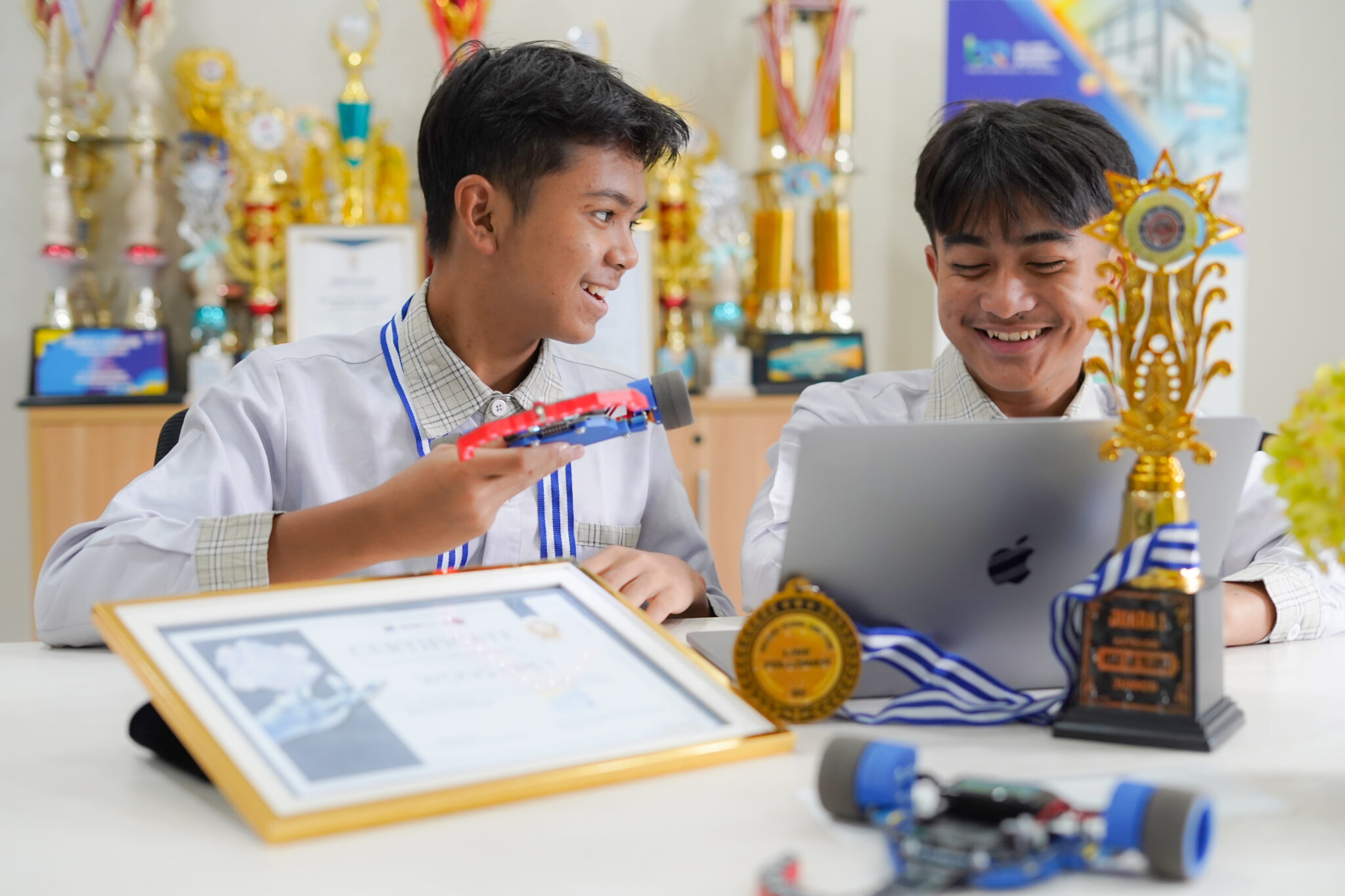 Santri tim robotik bersama robot line follower, piagam, dan piala