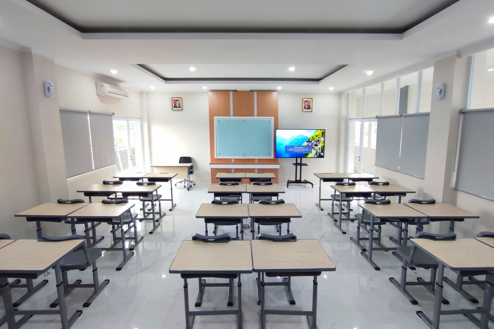 Ruang kelas dengan meja belajar dan layar televisi