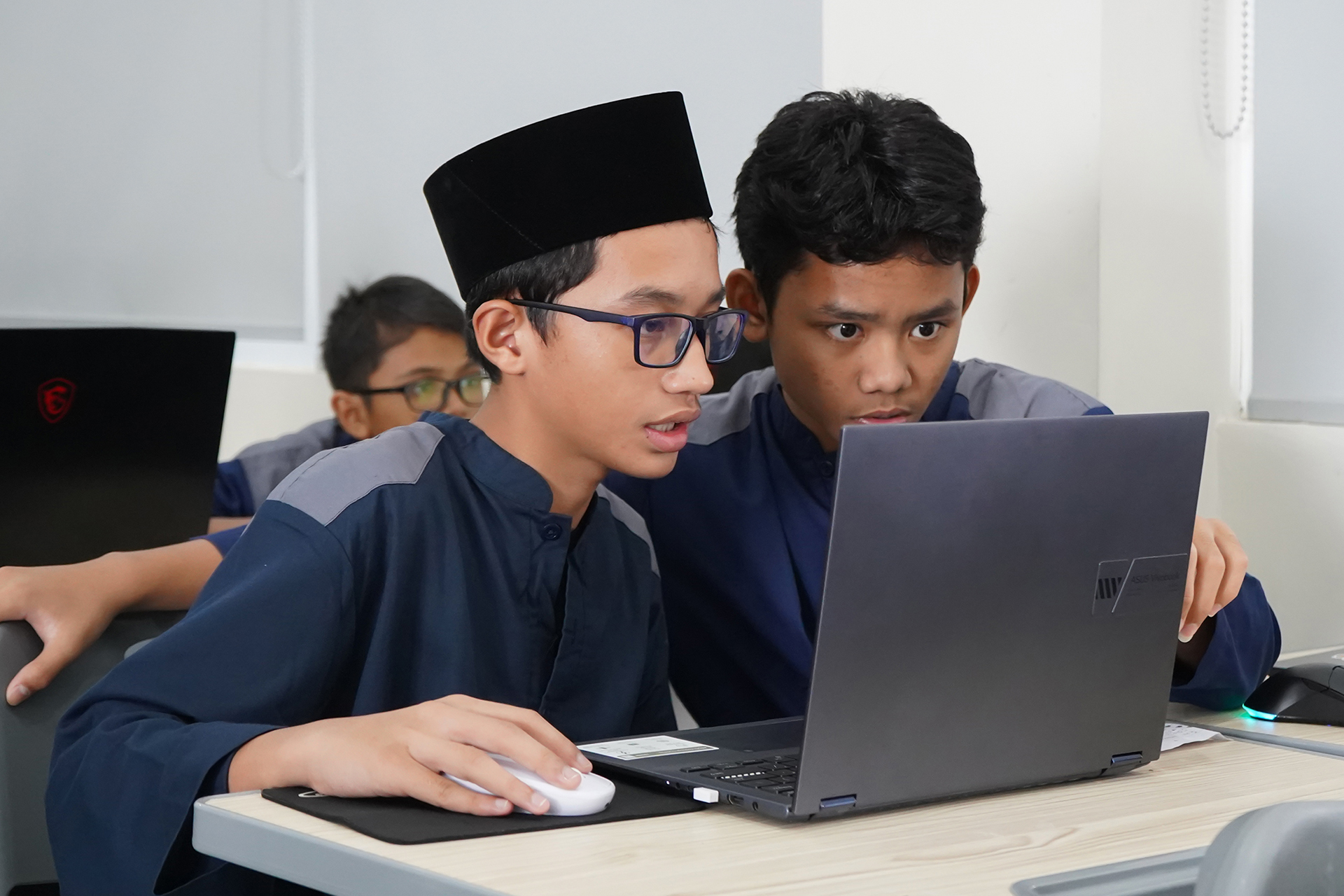 Dua santri belajar bersama di depan laptop