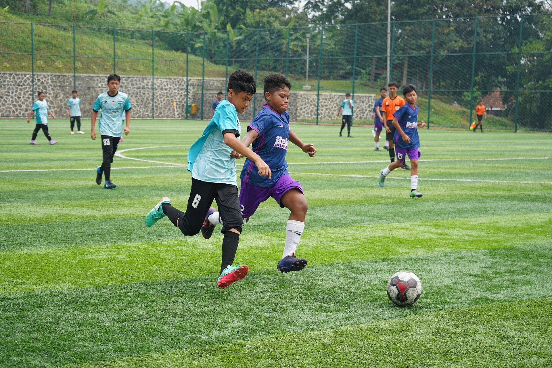 Santri bermain sepak bola di lapangan rumput