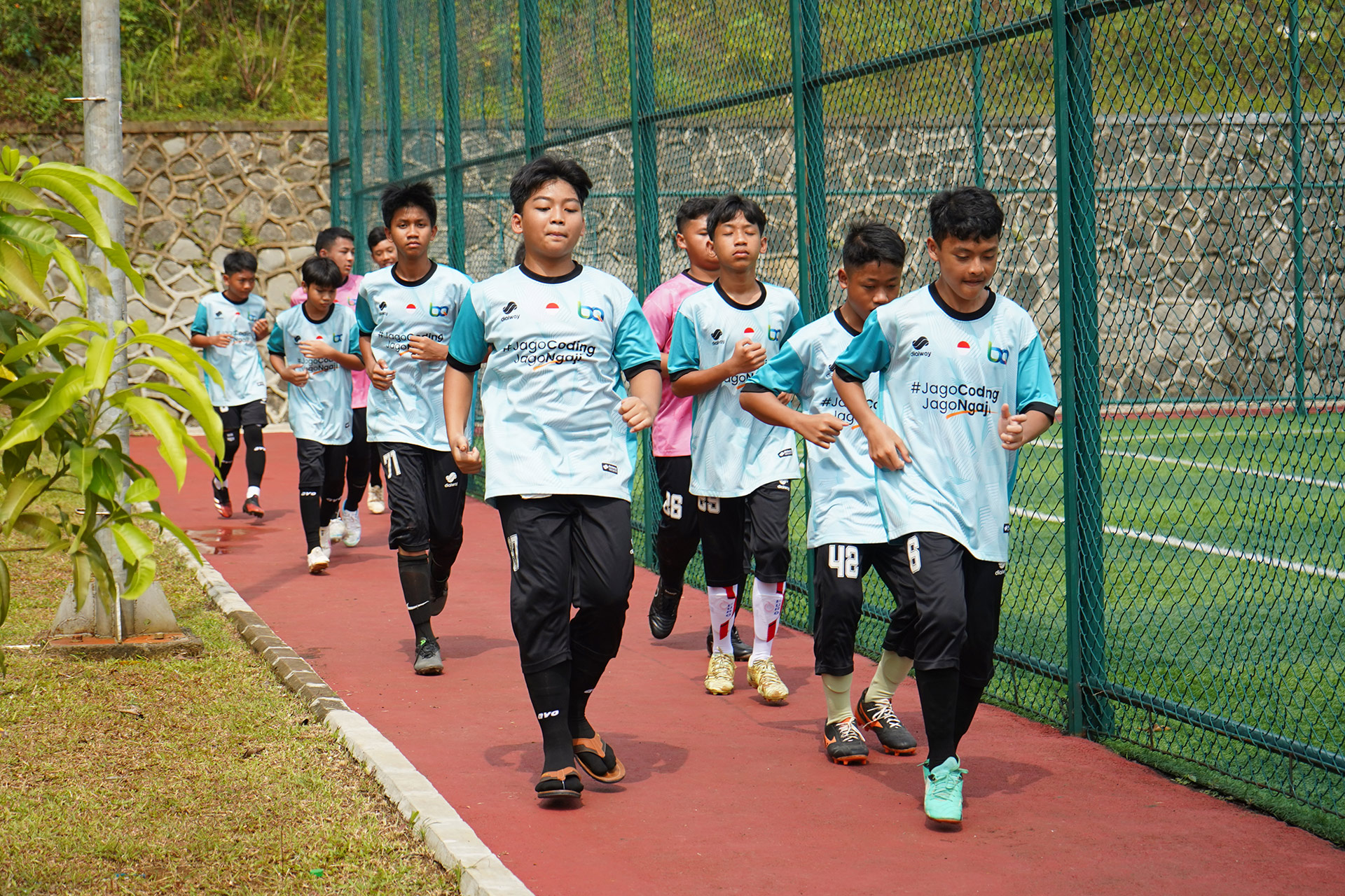 Santri berlari bersama di lintasan dekat lapangan